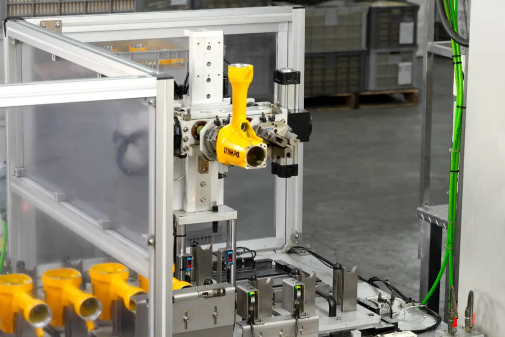 Automated robotic production line performing secondary CNC machining on yellow pneumatic tool bodies to achieve ±0.01 mm tolerances.